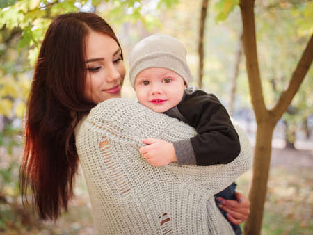 The girl is holding her son in the parkの写真素材