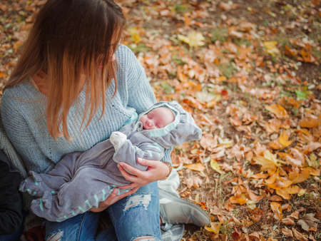 The girl is holding her son in the park