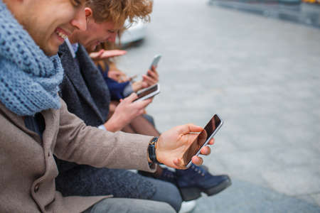 Funny young company having fun and laughing outdoors.の写真素材