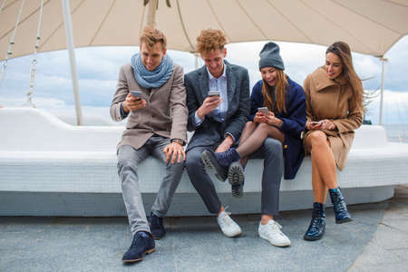 Funny young company having fun and laughing outdoors.