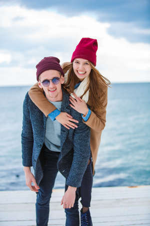 Cheerful young couple having fun and laughing together outdoors.の写真素材