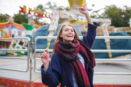 Beautiful young girl having fun and laughing in the amusement park.の写真素材