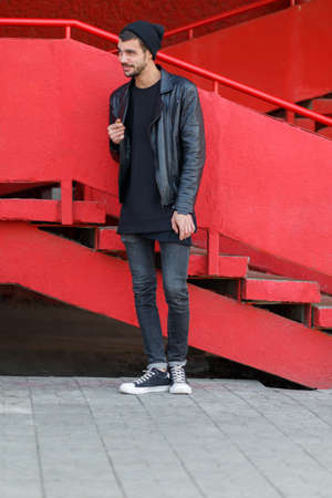 Handsome young man posing on the camera on a red background.の写真素材