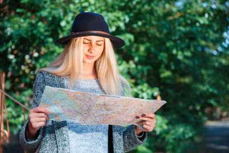 A girl in a hat looks at the map.の写真素材