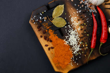 Composition with a cutting board, spices and hot pepper on a wooden backgroundの写真素材