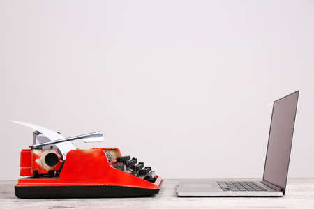Old typewriter and laptop on table. Concept of technology progress