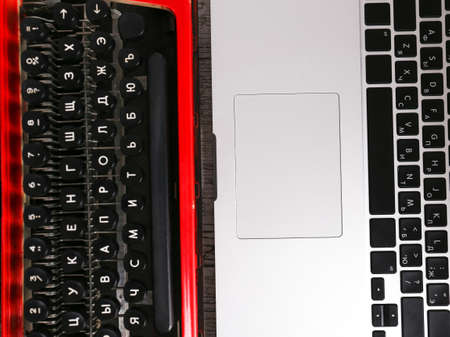 Old typewriter vs laptop on table. Concept of technology progress
