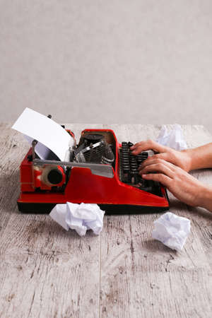 Hands of a man typing on a red typewriter maschineの写真素材