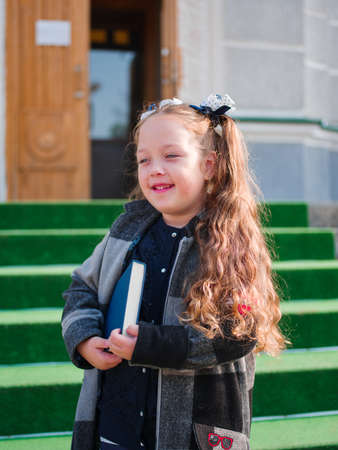 Close-up of a cute little girl with a book in her hands.