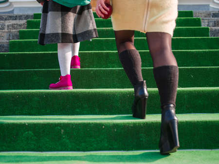 Close-up of a schoolgirls leg and her mom are walking up the stairs to schoolの写真素材