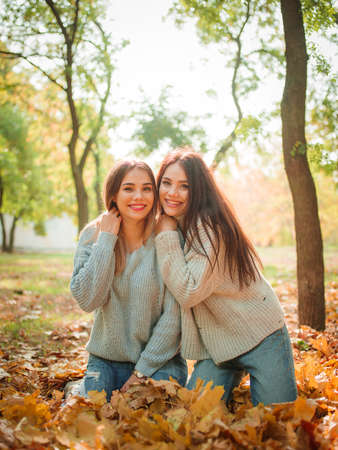 Close-up of beautiful girls, twins sisters, in autumn parkの写真素材