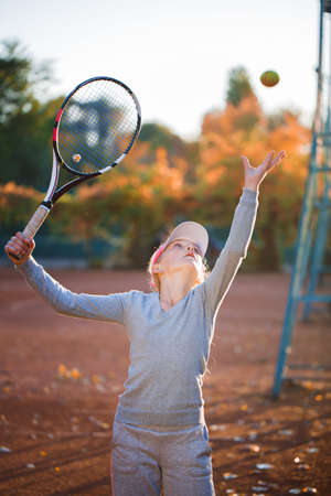 A teenage girl playing tennis on a tennis courtの写真素材