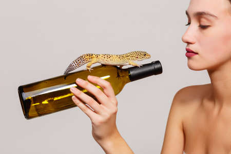 Girl with a lizard on a gray backgroundの写真素材