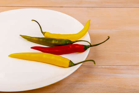 Spicy colorful pepper in a plate on a tableの写真素材