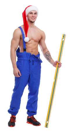 Muscular torced man in uniform on white isolated background in the New Years cap. Isolated over white backgroundの写真素材