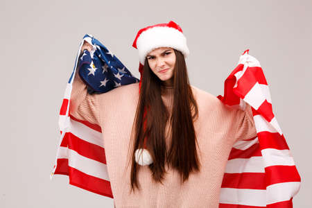Girl upset posing with American flag on gray backgroundの写真素材