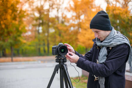 The videoblogger adjusts his cameraの写真素材