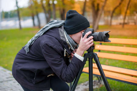 The video blogger makes his report and chooses a place where he will do itの写真素材