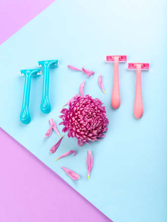 Set for hair removal. Blue and pink womans razor on the colorful background. Beautiful roses and pionies lying near the razors. Close-up of objects.の写真素材