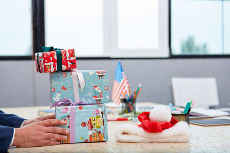 A man puts a few gift boxes on the desk in the office. Inside.の写真素材