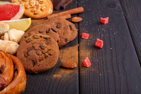 On the wooden table, various fragrant bakes, cinnamon sticks, chocolate slices, candied fruits and citrus. Inside.の写真素材