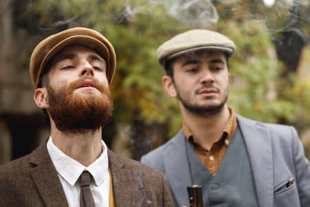 Two gangsters on the street looking for someone in the distance. Retro. Outdoors.の写真素材