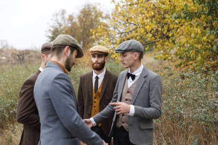 Several gangsters are discussing something on the street. Retro. Outdoors.の写真素材