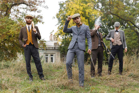 Several gangsters with weapon are looking for someone in the distance. Retro. Outdoors.の写真素材