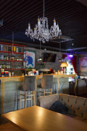 Interior of a stylish cafe, close-up of a large crystal chandelier, bar counter. Concept interior.の写真素材
