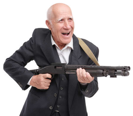 Elderly grandfather in a suit holds a shotgun aiming, isolated on a white background