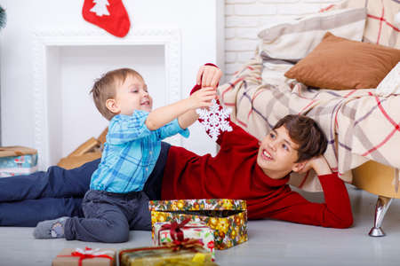 Portrait of charming brothers with Christmas giftsの写真素材