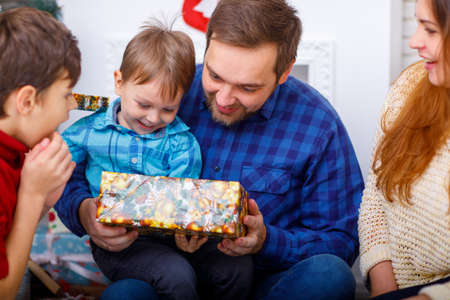 Happy family at Christmas in the house with gifts.の写真素材