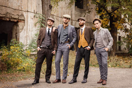 A group of dangerous retro gangsters in the park put their hands in their pockets.の写真素材