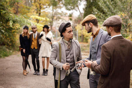 Group of dangerous retro gangsters in the park, preparing to attack