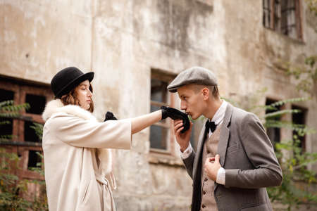 Gangsters. Against the background of an abandoned building in the forest, a man kisses a womans hand.の写真素材