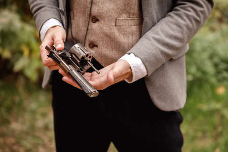 Close-up of a gangsters hand in which a gun.の写真素材