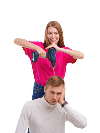 A girl wants to drill a guys head on a white isolated backgroundの写真素材