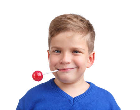 A boy holds a lollipop in his mouth behind a wand close-up on a white isolated backgroundの写真素材