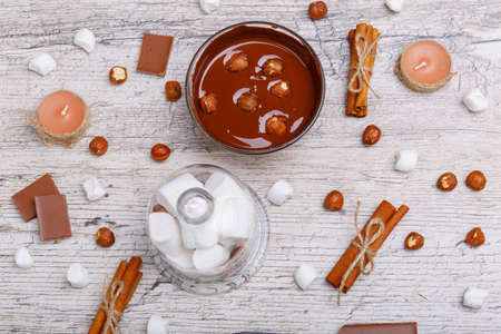 Chopped milk chocolate with nuts in a bowl next. View from aboveの写真素材