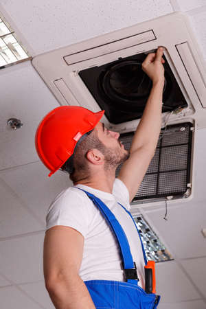 Locksmith examines ventilation in the ceilingの写真素材