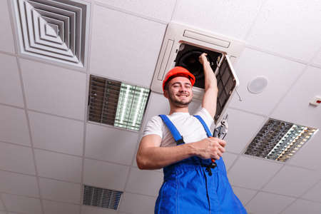 A mechanic holds one hand with ventilation while in another toolの写真素材
