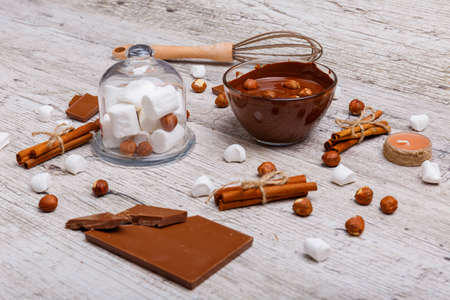 Chopped milk chocolate with nuts next to marshmallow on the tableの写真素材