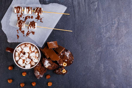 Hot chocolate with marshmallows in a cup next to marshmallow in chocolateの写真素材