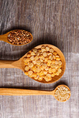 Wooden spoons different with cereals horizontally close-up on a tableの写真素材