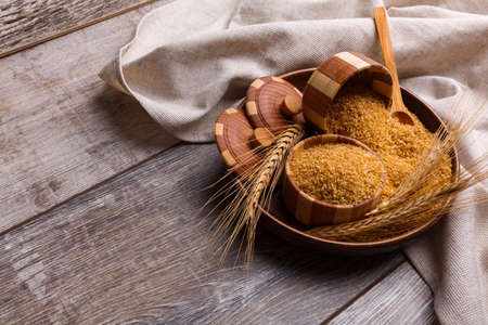 Wheat porridge in a plate in a wooden plateの写真素材