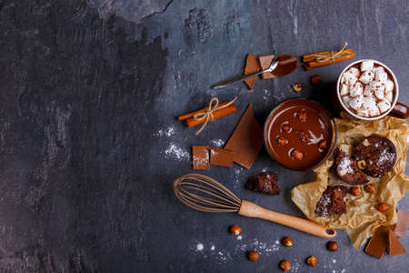 A cup of melted chocolate with hazelnuts and a cup of marshmallow in chocolateの写真素材