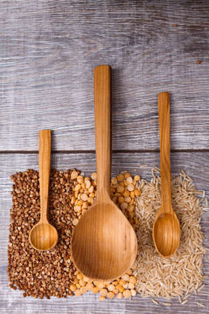 Three different spoons lie on the vertical strips of cereals at the bottom of the tableの写真素材