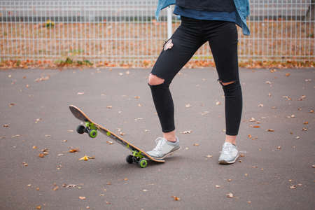 The girl lifted a skate with one foot in a skate parkの写真素材