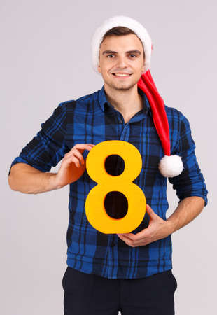 A young man in Santas hat with a figure of eight in his handsの写真素材