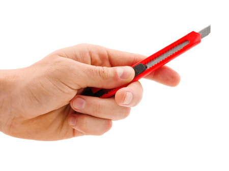 Red stationery knife in hand isolated on white backgroundの写真素材